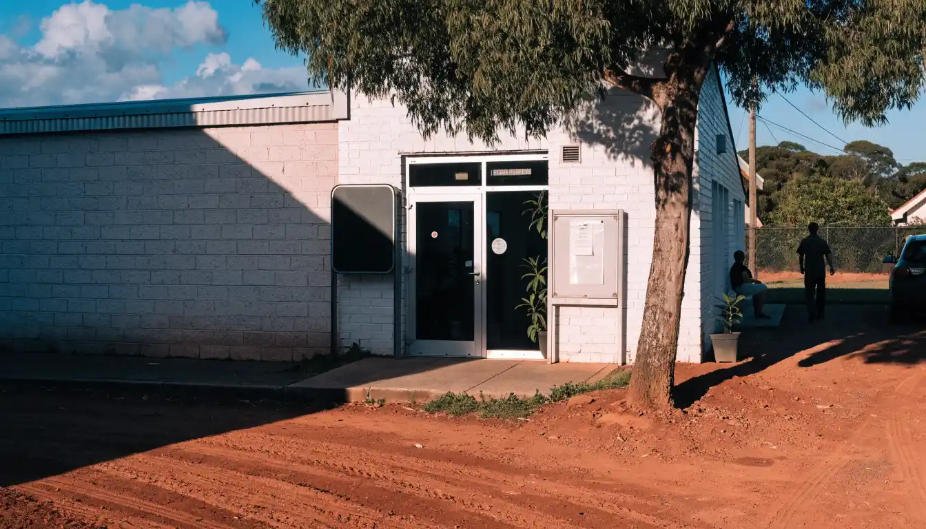Darwin government office under tropical sun with notice board at entrance